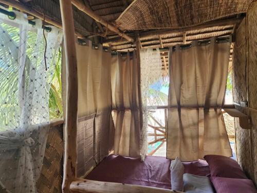 a bed in a room with a window at BICE Camp Bucana Beach in El Nido