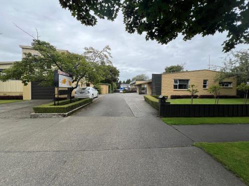 a street in a neighborhood with a house and a car at Golden Leaf Apartments in Invercargill