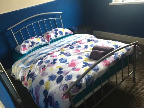 Bett mit Blumendecke in einem Schlafzimmer in der Unterkunft Liverpool Recently Refurbished Spacious House in Liverpool
