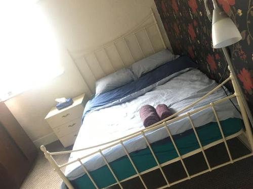 ein Bett mit lila Schuhen darauf in einem Schlafzimmer in der Unterkunft Liverpool Recently Refurbished Spacious House in Liverpool