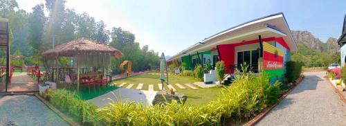 a building with a playground next to a garden at บ้านพักชายคลอง @บางปู สามร้อยยอด in Ban Bang Pu