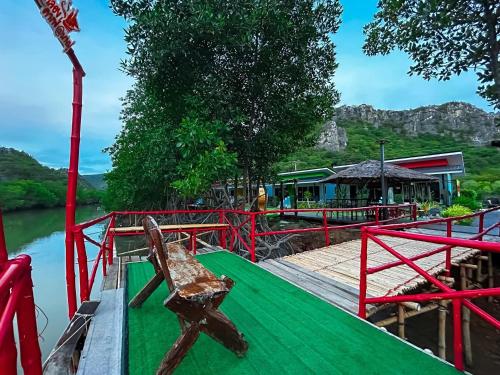 a bench sitting on a dock next to the water at บ้านพักชายคลอง @บางปู สามร้อยยอด in Ban Bang Pu