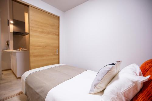Ένα ή περισσότερα κρεβάτια σε δωμάτιο στο Ekimae apartment