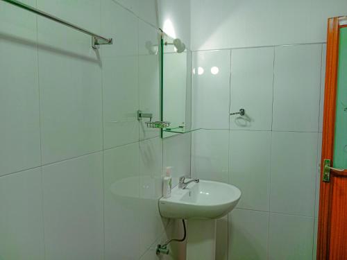 a white bathroom with a sink and a shower at Sigiriya Peacock Homestay in Sigiriya