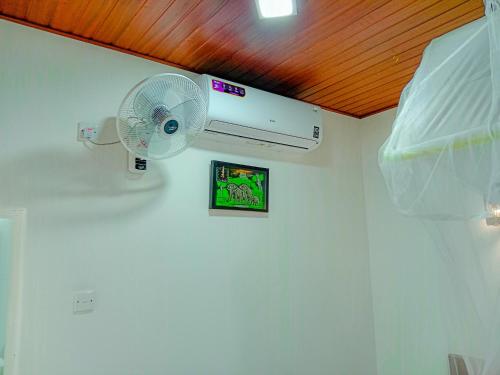 a white room with a white fan on a wall at Sigiriya Peacock Homestay in Sigiriya