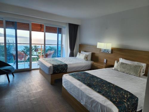 モンテゴ・ベイにあるHotel 39 Jamaicaのベッド2台とバルコニーが備わるホテルルームです。