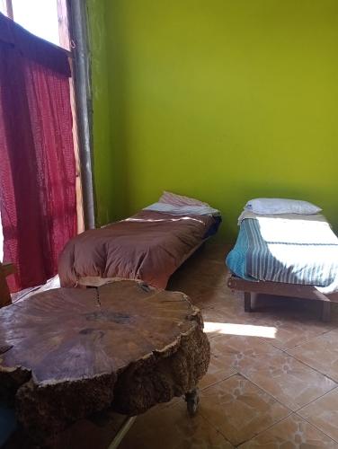 Duas camas num quarto com uma parede verde em Camas para descansar en habitación compartida em San Carlos de Bariloche