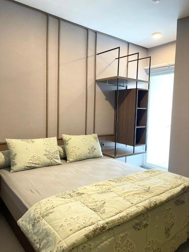 a bedroom with a bed with pillows on it at 2 BR I ANDERSON I 22floor I above pakuwon mall I the biggest shopping center in Surabaya