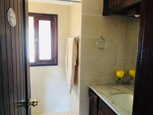 ein Bad mit einem Waschbecken und einem Fenster in der Unterkunft Villa Carolina in Punta del Este