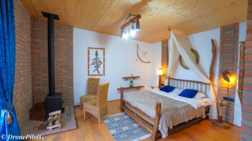 a bedroom with a bed and a fireplace at Villa Vejini cabin in Mamkoda