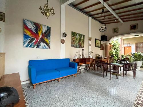 a living room with a blue couch and a dining room at Urbanview Syariah Hotel Kanigara Batu in Batu