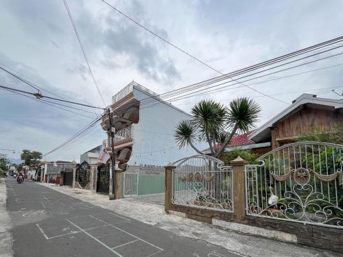 an empty street with a fence and a building at Urbanview Syariah Hotel Kanigara Batu in Batu