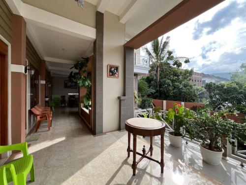 a balcony with a table and some plants at Urbanview Syariah Hotel Kanigara Batu in Batu