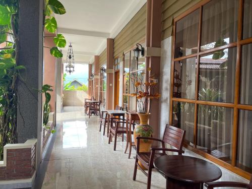 a corridor of a restaurant with tables and chairs at Urbanview Syariah Hotel Kanigara Batu in Batu