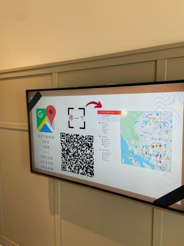 a projection screen on a wall with a map at Greet Inn in Kaohsiung
