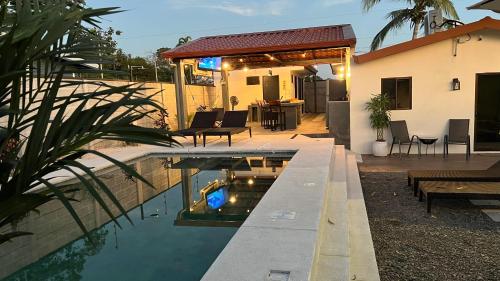 a swimming pool in front of a house at La Casa de Papi. in Parrita