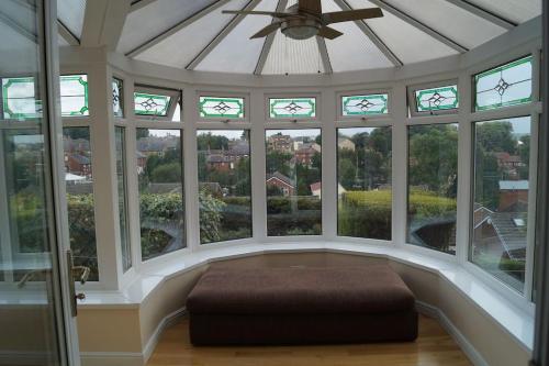 une grande chambre avec des fenêtres dans l'établissement 3 Bed House with Exceptional view, à Batley
