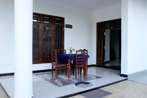 mesa con sillas y mantel azul en Nirwana Villa, en Mirissa