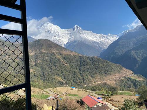 a view of a snow covered mountain from a window at hotel aagan in Kāskī