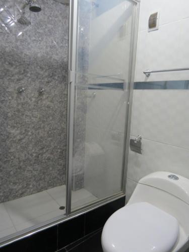 a bathroom with a toilet and a glass shower at Hospedaje EL RINCONCITO II in Jauja