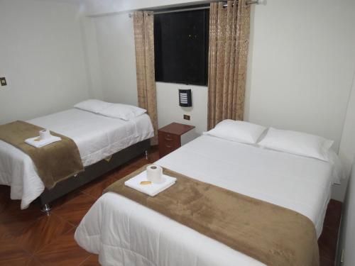 a hotel room with two beds and a window at Hospedaje EL RINCONCITO II - Cerca al Aeropuerto Jauja in Jauja