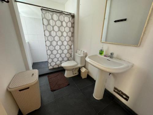 y baño con lavabo, aseo y espejo. en Apartamento Florentino 201, en Lima