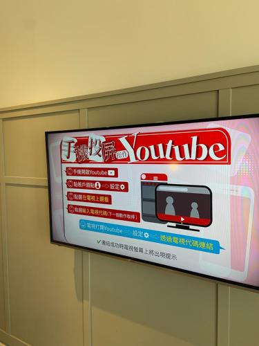 a television on a wall with a box on it at Greet Inn in Kaohsiung