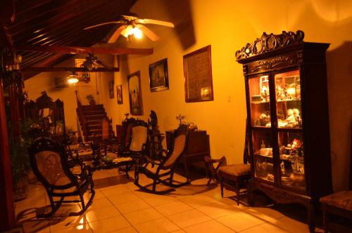 a living room with chairs and a cabinet with dishes at Hotel Real Leon in León