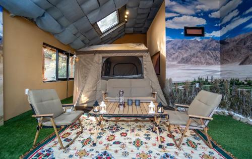 a tent with a table and chairs in a room at De Vivre Homestay Măng Đen in Kon Von Kla