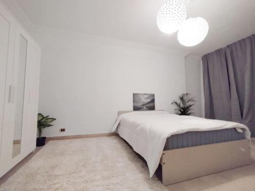 een witte slaapkamer met een groot bed in een kamer bij Nile white bear in Caïro