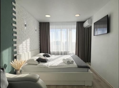 um quarto com uma cama e uma grande janela em Апартаменты с видом на город em Pavlodar