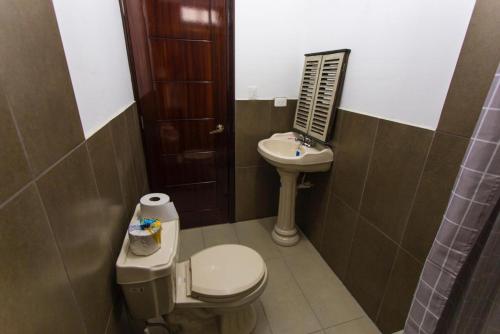 a small bathroom with a toilet and a sink at Mirador Departamento in Loja