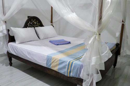 un dormitorio con una cama con dosel en Nirwana Villa, en Mirissa
