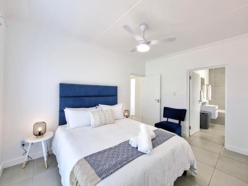 a bedroom with a large bed with a blue headboard at Apartment 276 Ballito Village in Ballito