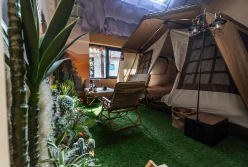 a tent with a chair and a table and some plants at De Vivre Homestay Măng Đen in Kon Von Kla
