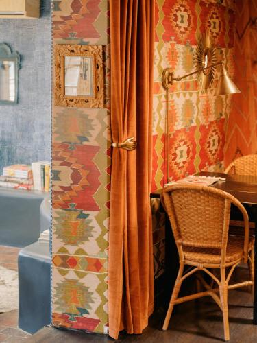 a room with a chair and a desk and a curtain at Pueblo Bonito Inn in Santa Fe