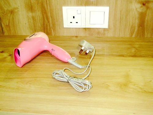 a pink corded phone sitting on a wooden floor at RG Grand Hotel in Parit Raja