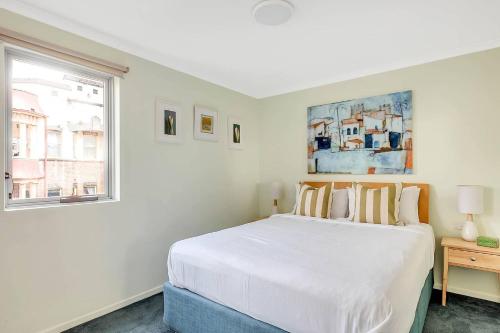 a bedroom with a white bed and a window at Charming Chippendale Escape with Rooftop Pool in Sydney
