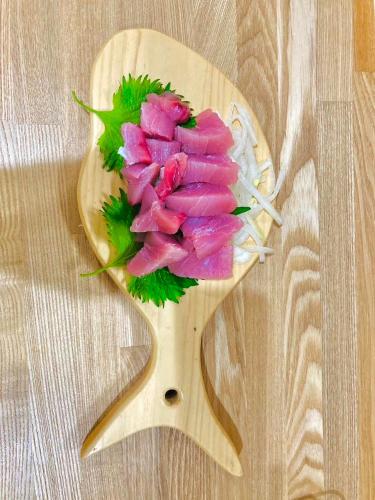a bunch of pink flowers on a wooden cutting board at ゲストハウスみんちゅう in Sukumo