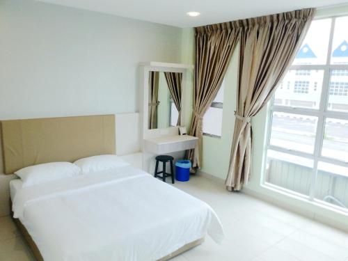 a bedroom with a bed and a sink and a window at RG Grand Hotel in Parit Raja