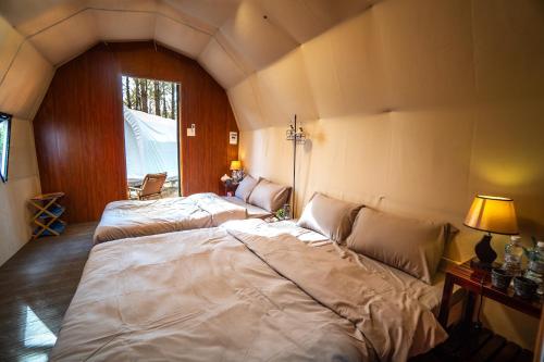 a bedroom with two beds in a room at De Vivre Homestay Măng Đen in Kon Von Kla