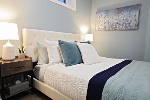 a bedroom with a bed with blue and white pillows at Queen Bed,Near Airport,Kids Playground,Disney+ in Edmonton