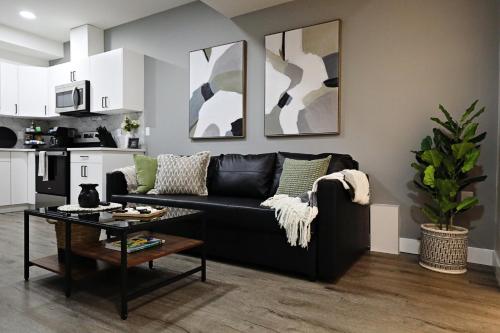 a living room with a black couch and a table at Queen Suite 20 Min from YEG Airport with Disney in Edmonton