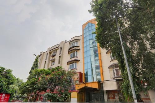 budynek na ulicy z drzewami przed nim w obiekcie OYO Hotel M & c w mieście Patna
