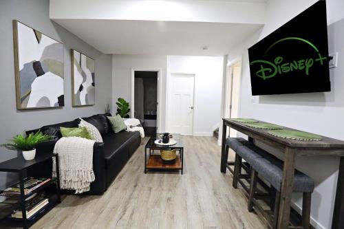 a living room with a black couch and a table at Queen Suite 20 Min from YEG Airport with Disney in Edmonton