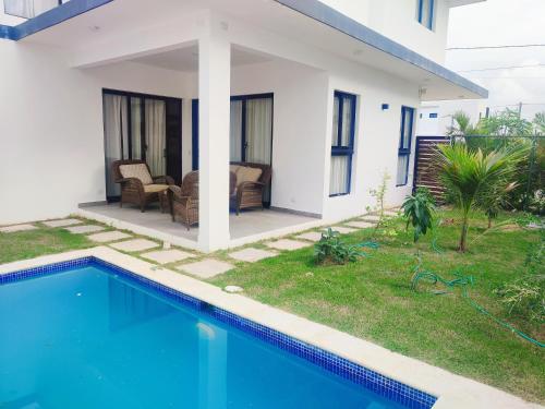 uma villa com uma piscina e uma casa em Hermosa Villa en punta cana em Punta Cana