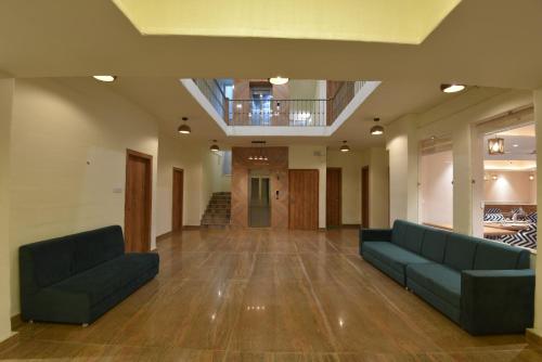 a living room with two couches and a staircase at Ekawa Ganga by Lawrence Hotels in Rishīkesh