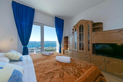 um quarto com uma cama grande e uma janela grande em Apartments Marko - amazing sea view em Brela