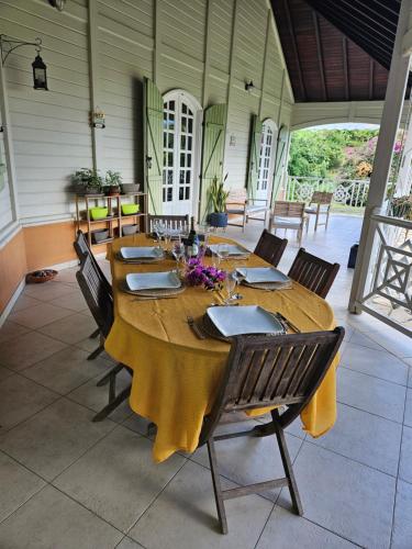 a large wooden table in a room with chairs at Villa les Bougainvilliers in Rivière-Pilote