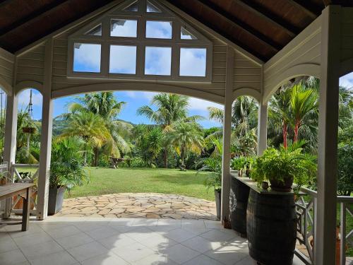 an open gazebo with a view of a garden at Villa les Bougainvilliers in Rivière-Pilote